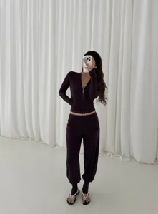 Stylish women's zip-up athletic jacket and stirrup pants set, comfortable yoga fitness wear.