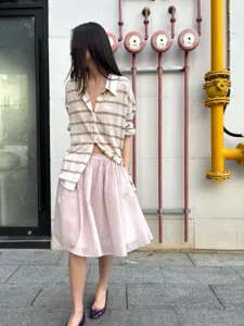 Rosa Tüll-Midirock mit Falten und gestreiftem Poloshirt, stilvolles Casual-Outfit Detailansicht.