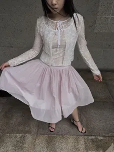 Weißer Spitzen-Cardigan mit hellrosa plissiertem Tüllrock, Detailansicht im Balletcore-Stil.