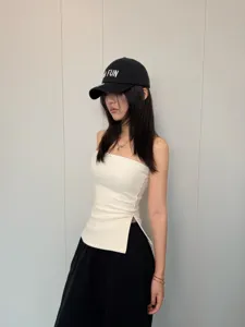 Detaillierte Nahaufnahme des weißen, strukturierten elastischen Trägershirts mit Seitenschlitz.