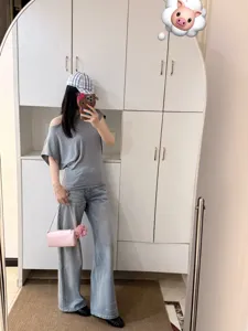 Outfit casual da donna con elegante top grigio con spalle scoperte e jeans chiari.