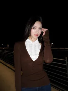 Detail shot of the stylish brown long-sleeve top with white collar, showing fabric texture and design.