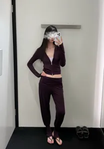 Detailed view of women elegant purple yoga activewear set, zip jacket and stirrup pants.