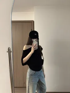 Dettaglio di jeans dritti a vita media in denim chiaro slavato abbinati a un top nero.