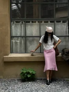 Detail view of stylish pink bias cut fishtail midi skirt, elegant and chic daily wear.