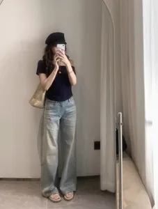 Vista dettagliata dei jeans dritti a vita media slavati in azzurro stile retro minimal.
