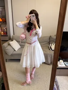 Detailansicht des weißen Tüll Faltenrocks mit rosa Accessoires im süßen Balletcore Stil.