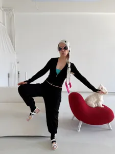 Black zip sports activewear set with trendy headscarf and stylish pose detail view.