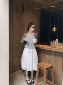 Elegantes weißes Tüll-Midirock Detail für Damen in gemütlicher Café-Atmosphäre an.
