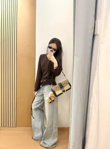 Vista dettagliata di jeans casual lavaggio chiaro a gamba larga con effetto usato.