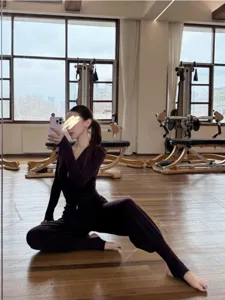 Detailed showcase of women yoga fitness slim zip top and comfortable stirrup pants in dark purple.