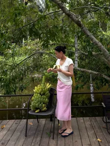 Detailed view of the pink asymmetrical fishtail midi skirt, linen fabric, outdoor lifestyle.