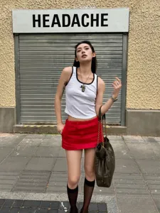 Detailansicht der stilvollen roten Urlaubsshorts kombiniert mit weißem Top und Tasche.