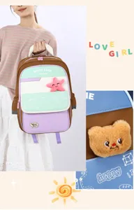 Detailed view of the cute color-blocked student backpack with plush bear and starfish charms.