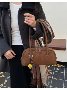 Brown vintage style women shoulder pillow bag detail, featuring nice stitching and elegant charm.