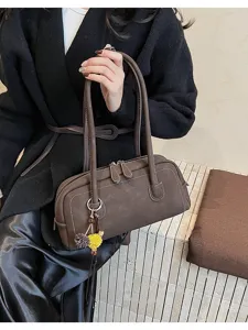 Dark brown retro pillow shoulder bag detail view with white stitching and cute floral charm.