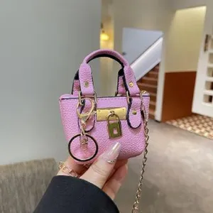 Mini pink leather handbag charm keychain with gold chain and lock detail, stylish accessory.