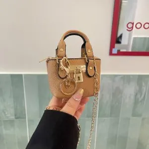Mini tan leather handbag charm with gold hardware, chic crossbody bag for women and girls.