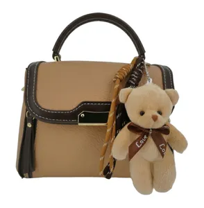Stylish contrast color shoulder bag with cute teddy bear pendant for women and girls daily use.