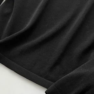 Gros plan detaille de la texture en tricot noir, vue macro de maille douce et souple.