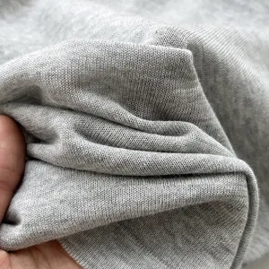 Détail de tissu en maille grise semi-transparente, matériau élastique pour hauts respirants.