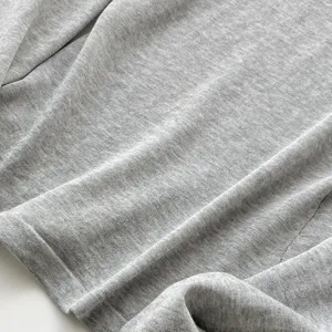 Détail de tissu de top en tricot gris texture douce, coupe slim extensible basique.