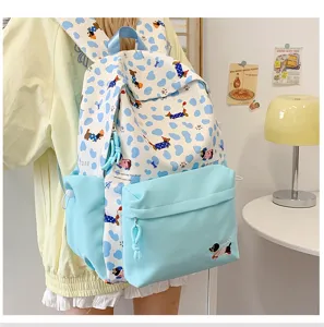 Detailed view of cute cartoon dog print school backpack in light blue, showing front pocket.