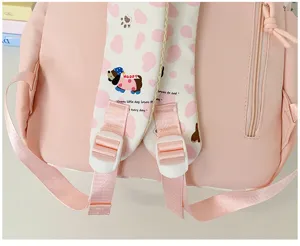 Pink backpack shoulder strap detail with cute dog print and adjustable buckle for daily use.