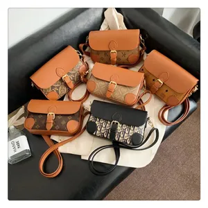 Detailed shot of fashionable monogram crossbody shoulder bags with vintage buckles on a dark surface.