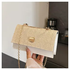 Gros plan détaillé d'un sac bandoulière tendance en paille tressée et cuir avec poignée métal.