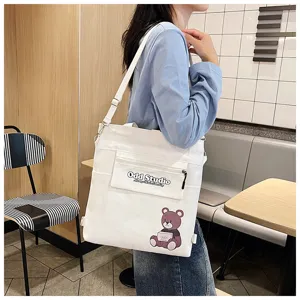 Detailansicht der vielseitigen weißen Segeltuchtasche mit Umhängeträger und Bärendruck.