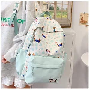 Closeup of light blue white polka dot backpack with cute dog print, front pocket design.
