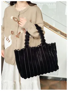Detail view of the black plush tote bag featuring stylish vertical stripes and bubble handle.