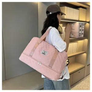 Pink quilted travel duffel bag detail in lifestyle setting with large capacity and shoulder strap.