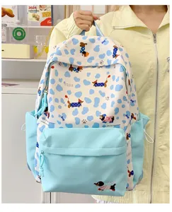 Close-up detail showing the cute dachshund dog pattern and zipper pocket on the backpack.