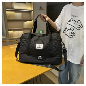 Detail view of black quilted travel duffel bag with bottom compartment, large capacity gym bag.