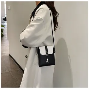 Detailed view of stylish mini crossbody phone bag, black and white contrast design with charm.