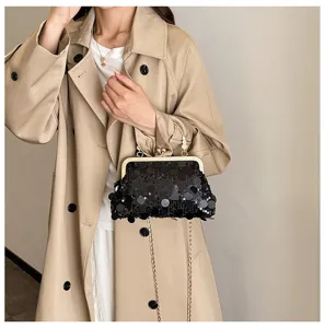 Detailed view of the stylish black sequin kiss-lock shoulder bag with gold chain strap.
