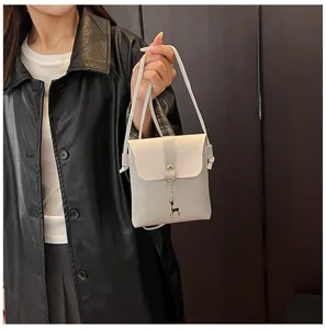 Detail shot of the mini crossbody phone bag with cute deer charm and chic clasp design.