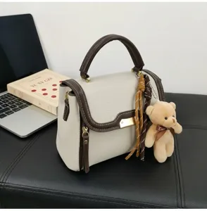 Stylish contrast color women shoulder handbag with cute bear pendant and top handle design.