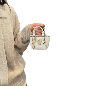 Trendy mini white handbag keychain with gold lock and chain, cute micro shoulder bag for women.