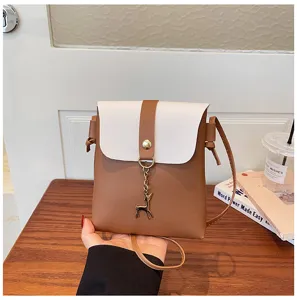 Detailed close-up shot of the mini crossbody bag with chic deer pendant and contrast color design.