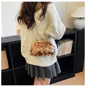 Detailed shot of a stylish sequin kiss-lock shoulder bag worn on a woman in an indoor setting.