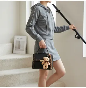 Stylish contrast color leather shoulder handbag with cute bear pendant for women detail view.
