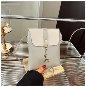 Close-up of stylish gray and white mini crossbody phone bag with cute deer pendant detail.