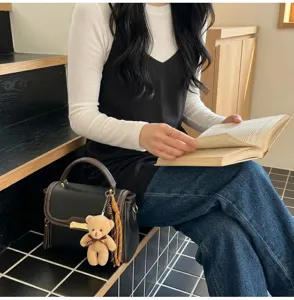 Fashion contrast color shoulder bag for women, stylish PU leather handbag with cute bear pendant.