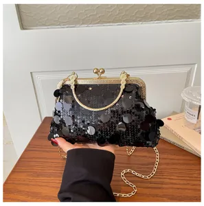 Black sequined clutch bag detail showing sparkling sequins and metal clasp handle.