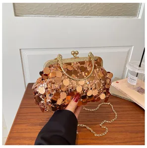 Detailed view of fashionable women sequin clutch bag with gold chain strap and metal frame.