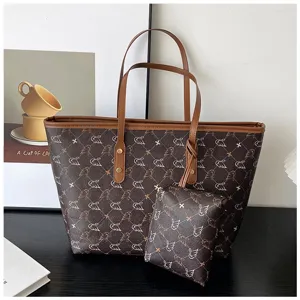 Detailed view of brown retro tote bag with matching pouch and elegant swan pattern design.