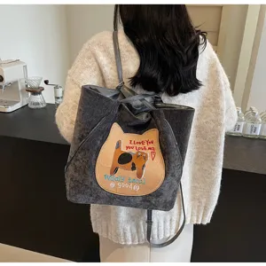 Detail view of the dark grey corduroy backpack featuring a cute cat embroidery patch and straps.